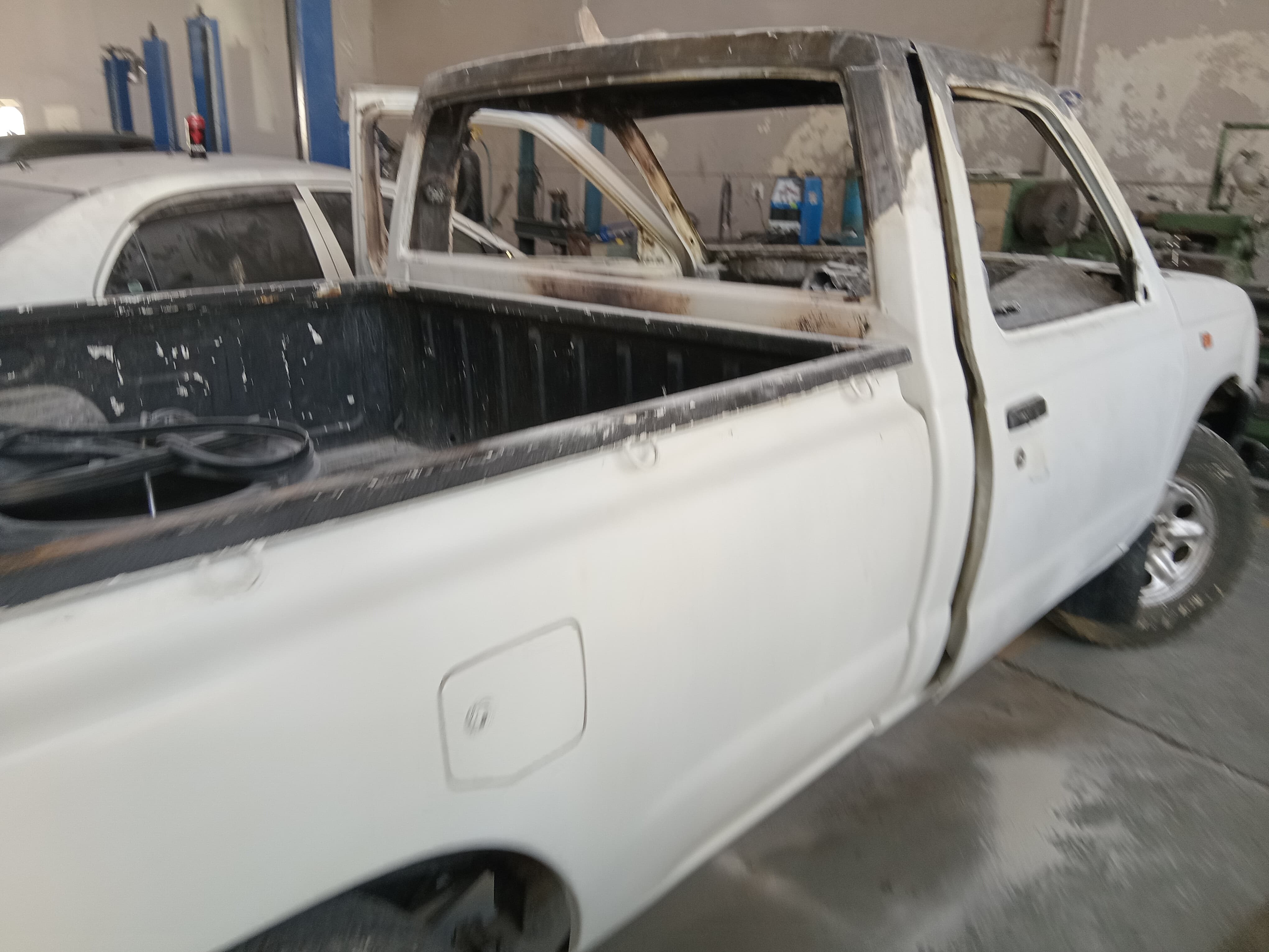 Pickup body undergoing panel preparation inside the workshop